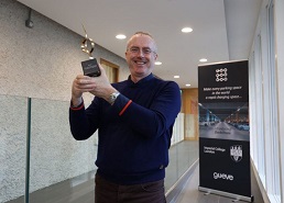 Image of Hugh Sheehy, co-founder and CEO of Go Eve holding a trophy.